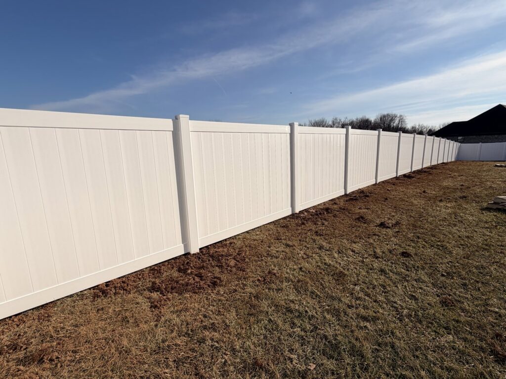 A long white vinyl privacy fence installed in a residential area by Shatkoff Fencing in Louisville, KY.