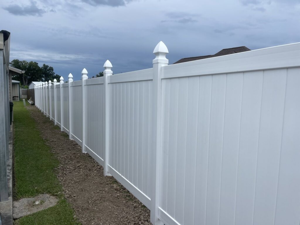 A long, newly installed white vinyl privacy fence by Southern Fencing, LLC in Houma, LA.