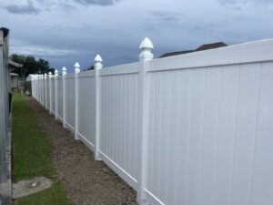 A long, newly installed white vinyl privacy fence by Southern Fencing, LLC in Houma, LA.