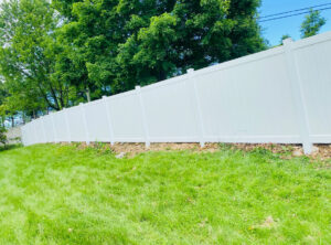 A long white vinyl privacy fence installed along a property line by Superior Fence & Rail of Northern Kentucky in Florence, KY.