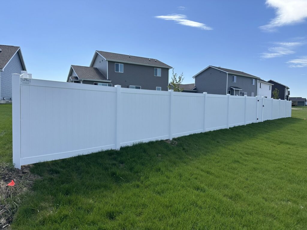 An extensive white vinyl privacy fence installed in a residential neighborhood by Top Rail Fence Des Moines in West Des Moines, IA.