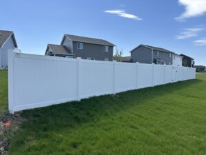 An extensive white vinyl privacy fence installed in a residential neighborhood by Top Rail Fence Des Moines in West Des Moines, IA.