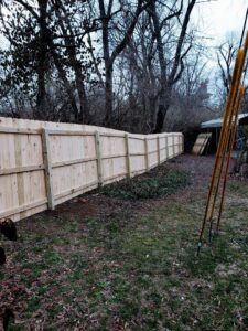 A long section of newly installed wood fence in a wooded backyard by Veteran Fence in North Royalton, OH.