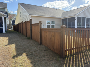 A long section of a residential wood fence, combining privacy and picket styles, installed by Stain and Go in Summerville, SC.