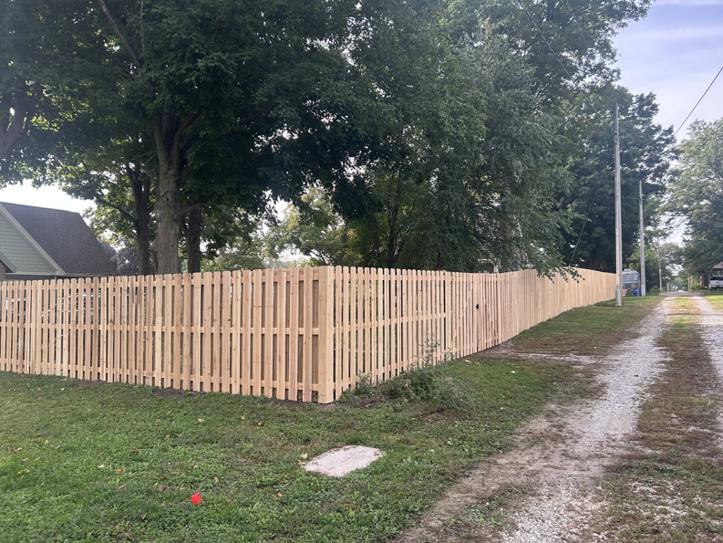 A long wood picket fence installed around a corner of a property by Walker Fence in Council Bluffs, IA.