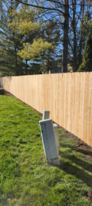 A long, newly installed wood picket fence defining a residential property line by CDM Home Solutions in Columbus, OH.