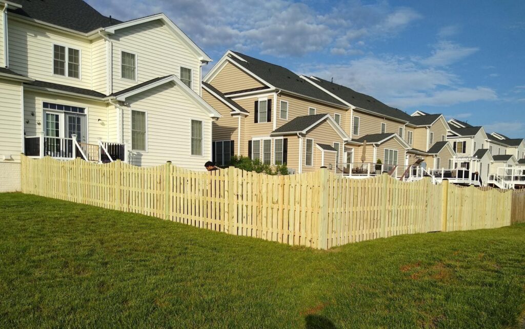 A long wooden picket fence installed in a residential neighborhood by Universal Fence LLC in Drainesville, VA.