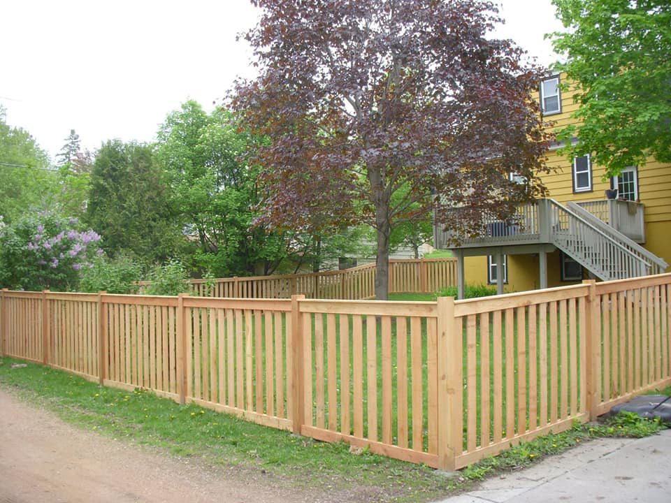 A long wood privacy fence installed along a sidewalk by Melanie K. Lynch in Crawfordville, FL