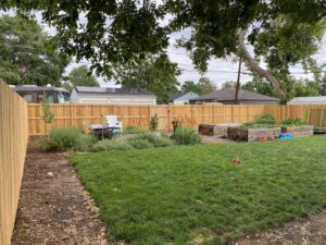 A long, sturdy wood privacy fence enclosing a spacious backyard, installed by Fence Guru LLC in Denver, CO.
