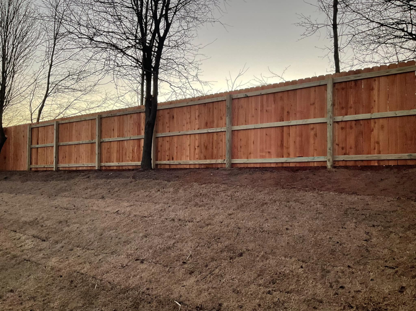 A long section of newly installed wood privacy fence in a residential backyard by Best Fences LLC in Springdale, AR.