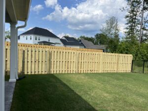 A long stretch of newly installed wood privacy fence in a spacious backyard by East Georgia Fence in Evans, GA.