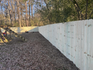 A long, newly installed wood privacy fence in a residential backyard by Precision Contracting LLC in Jupiter, FL.