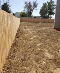 A long wood privacy fence installed along the perimeter of an empty residential lot by JBC Services LLC in Milwaukee, WI.