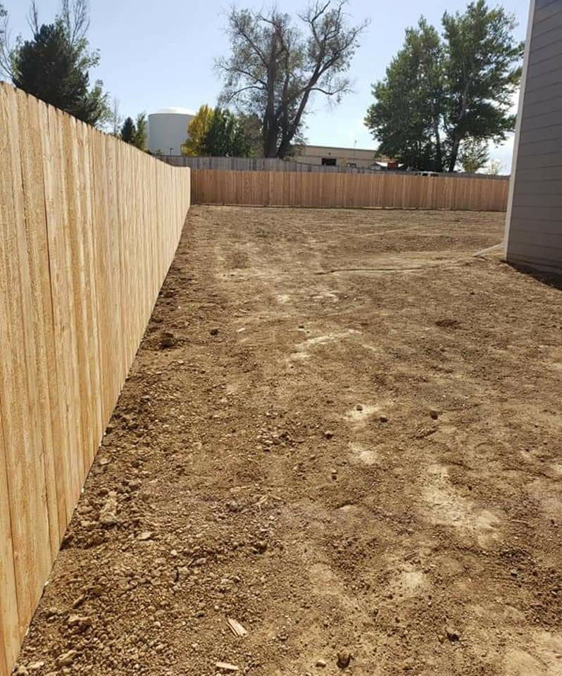 A long wood privacy fence installed along the perimeter of an empty residential lot by JBC Services LLC in Milwaukee, WI.