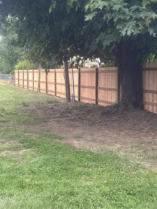 A long line of newly installed wood privacy fencing in a residential yard by FJ'S Fencing & Construction, LLC in Lake Oswego, OR.