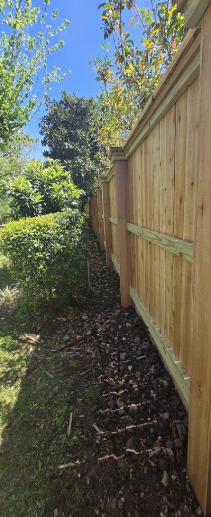 A long, newly installed wood privacy fence line extending along a residential property, built by Fence Builders of Houston, TX.