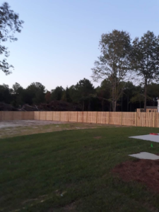 A long wooden privacy fence installed in a new construction area by Rowe Fence & Supply in New Kent, VA.