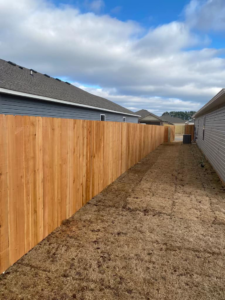 A long section of newly installed wood privacy fence between two residential homes by Best Fences LLC in Springdale, AR.