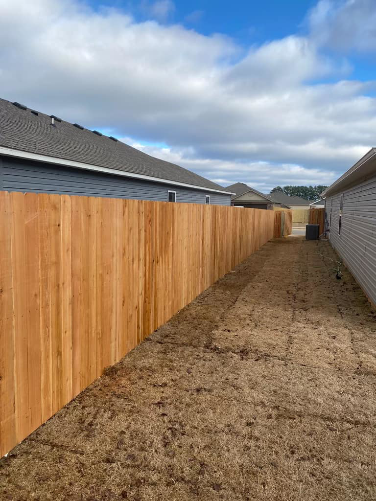 A long section of newly installed wood privacy fence between two residential homes by Best Fences LLC in Springdale, AR.