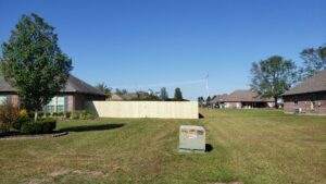 A long wooden privacy fence separating residential properties, installed by JH Fencing in Lawrence, KS.