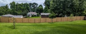 A long, newly installed wood privacy fence in a residential area by Top Rail Fence Birmingham, AL