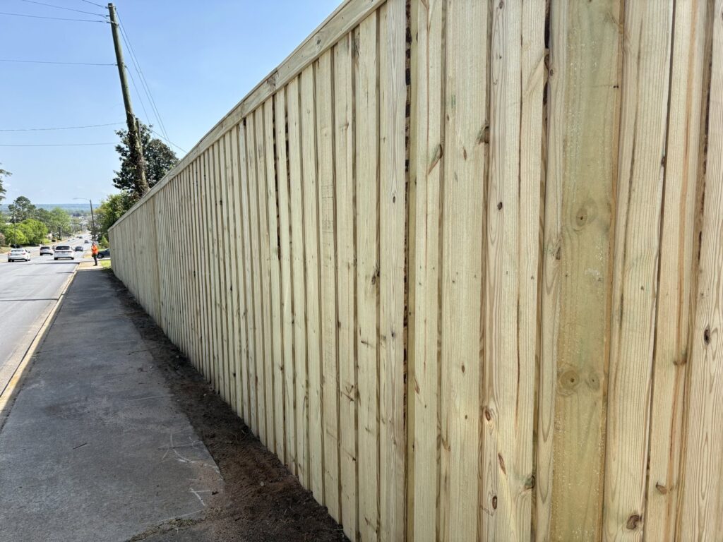 A long wooden privacy fence installed along a roadside by CSRA Solutions in Jackson, SC.