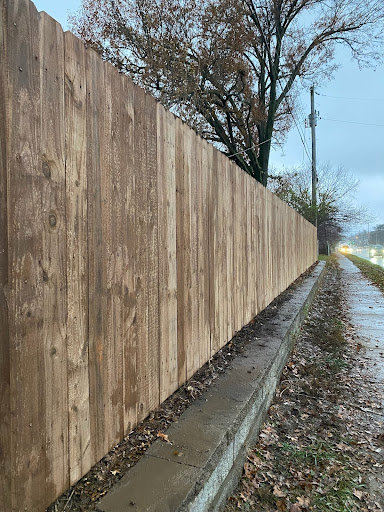 A long new wood privacy fence installed along a roadside by Sexton Property Services STL in High Ridge, MO.