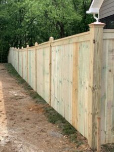 A long wood privacy fence with decorative post caps by Escamilla Fence Co. in Knoxville, TN