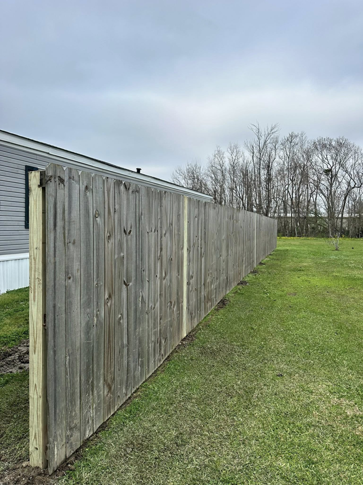 A long section of wooden fence with new posts installed by Gator Fence Co. in Miami, FL