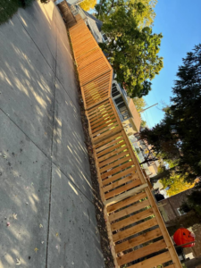 A long wooden fence with horizontal slats installed along a driveway by ALL STAR FENCE in Chicago, IL.