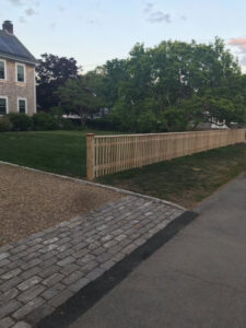 A long wooden picket fence installed along a residential street by Profence in Leander, TX.