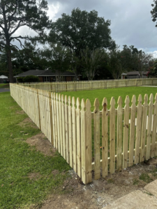 A long section of newly installed wooden picket fence surrounding a residential yard by J&L Fence in Zolfo Springs, FL.