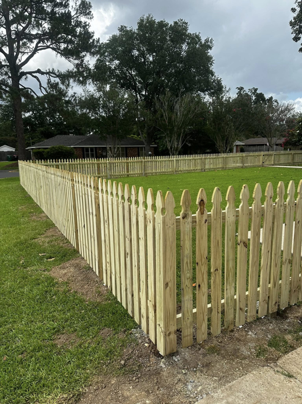 A long section of newly installed wooden picket fence surrounding a residential yard by J&L Fence in Zolfo Springs, FL.