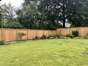 A long wooden privacy fence installed in a residential backyard by Creative Fence Designs in Columbus, GA.