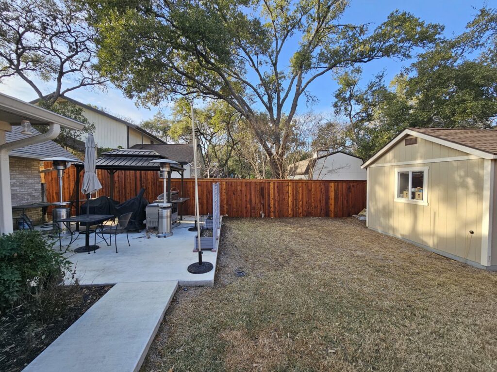 A long, well-maintained wooden privacy fence enclosing a residential backyard by Superior Fence Co. of San Antonio, TX.