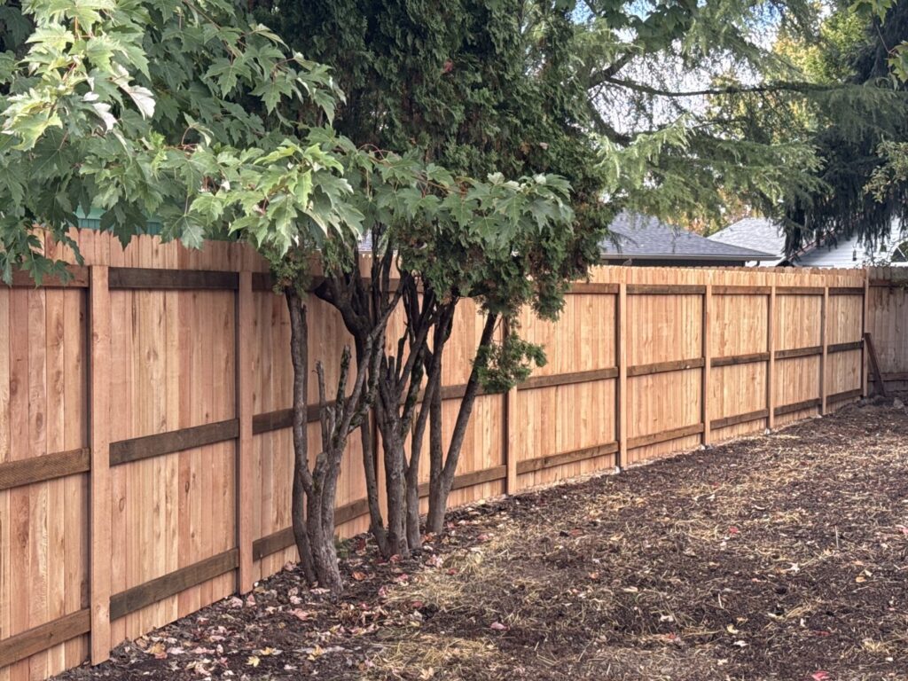 A long, newly installed wooden privacy fence along a property line by Faxon Fencing in Corvallis, OR.