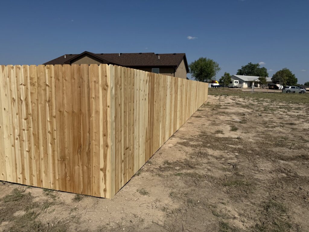 A long wooden privacy fence installation by Pueblo Fence Co in Pueblo West, CO.