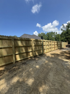 A long stretch of newly installed wooden privacy fence with a gate, completed by Littleton Construction LLC in the Service Area.