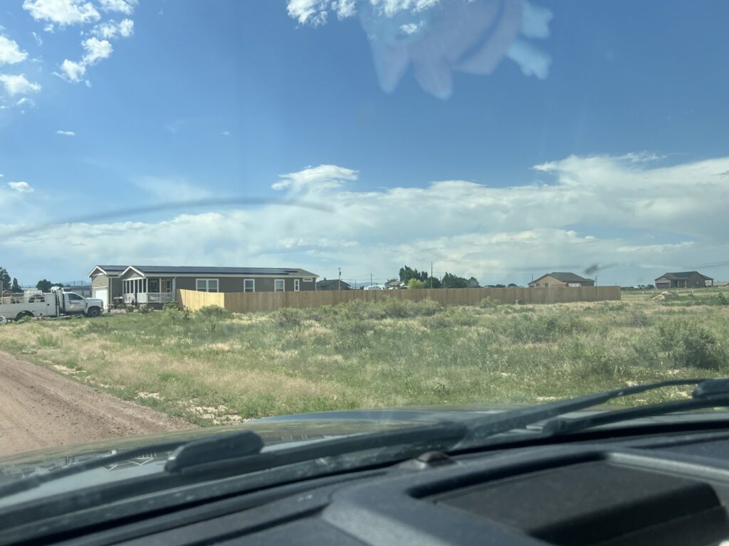 A long wooden privacy fence in a rural setting installed by Pueblo Fence Co in Pueblo West, CO.