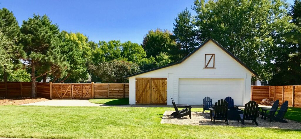 A long wooden privacy fence with a gate enclosing a spacious backyard by Complete Fence, LLC in West Chicago, IL