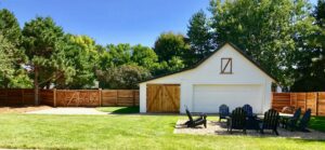 A long wooden privacy fence with a gate enclosing a spacious backyard by Complete Fence, LLC in West Chicago, IL