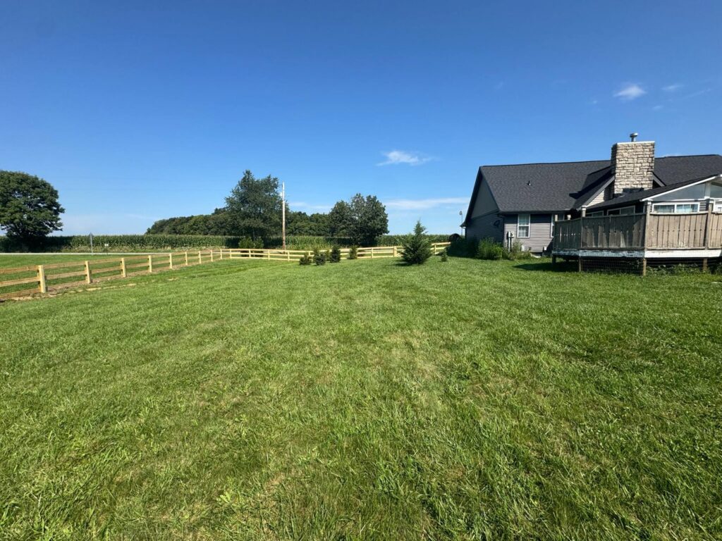 A long wooden split-rail fence extending across a rural landscape, installed by D&M Renovation Services LLC in Columbus, OH.