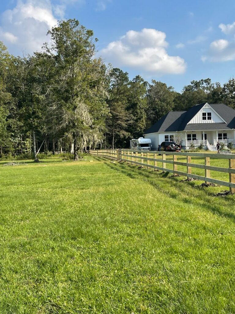 A long wooden split-rail style fence installed around a large property by Stono Fencing & Exteriors in Johns Island, SC