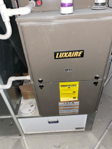 A Luxaire furnace unit with an EnergyGuide label, installed by Healthy Living Heating and Air Conditioning in Westland, MI.