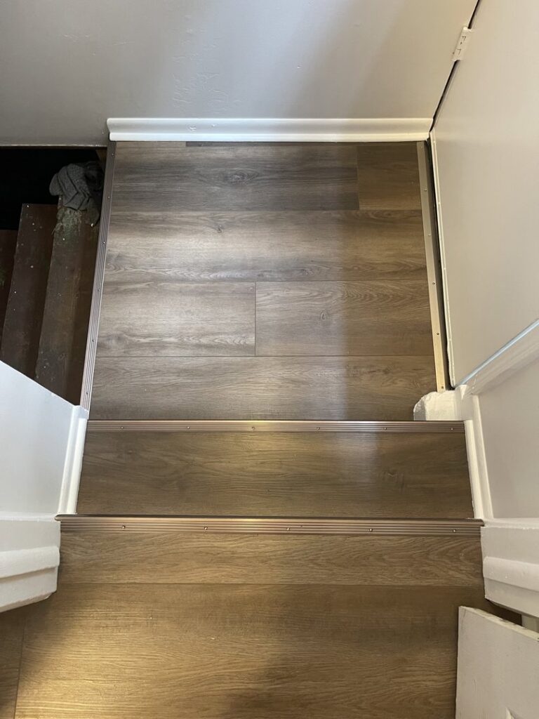 LVP flooring installed on stairs with metal nosing by Mendez Carpet in Grand Rapids, MI.