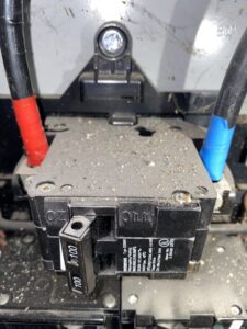 A close-up of a main circuit breaker with red and blue taped wires, showing the detailed electrical components serviced by AA Electric Contractors in Chicago, IL.