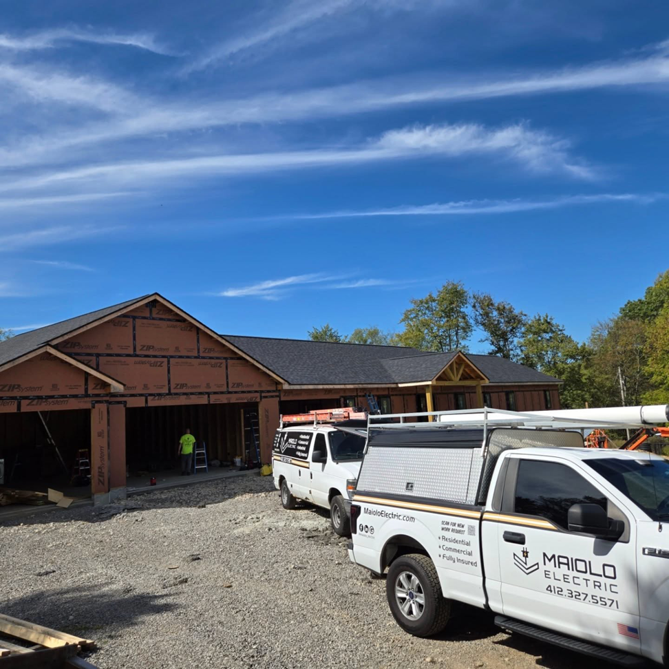 Maiolo Electric trucks parked at a new construction residential site in Pittsburgh, PA, ready for electrical installation.