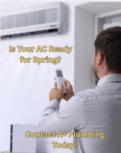 A man adjusting a wall-mounted AC unit with a remote control at A+ Plumbing Heating & Cooling in Manchester, NH.
