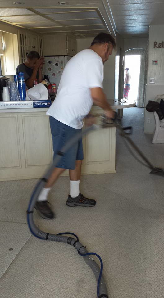 A man professionally cleaning a carpet with a machine for ABSOclean Carpet Cleaning in Phoenix, AZ.