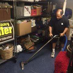 A man using a professional carpet cleaning machine on a blue carpet at Magic Cleaning Services in Billerica, MA.